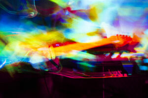 A guitar bathed in multicoloured lights.