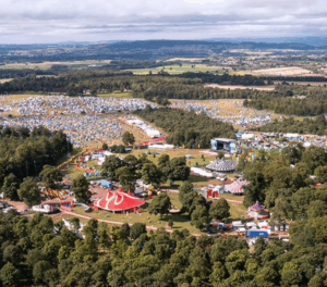 Drone Image of Kendal Calling Festival from above, sunny weather, with red big top tents, campsites and main stage in view.
