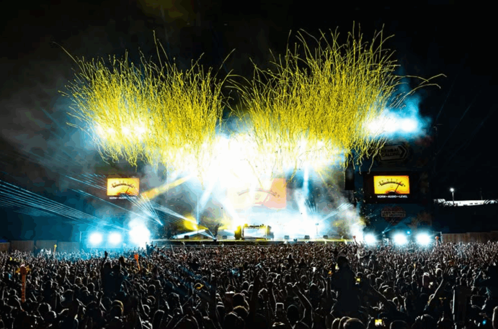 Yellow confetti being shot in the air to culminate Fatboy Slim's headline set at Kendall Calling 2025, backdropped by the night sky