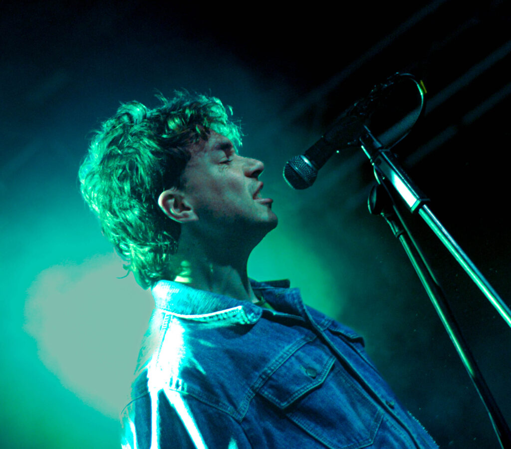 Sports Team lead singer Alex Rice sings into a microphone