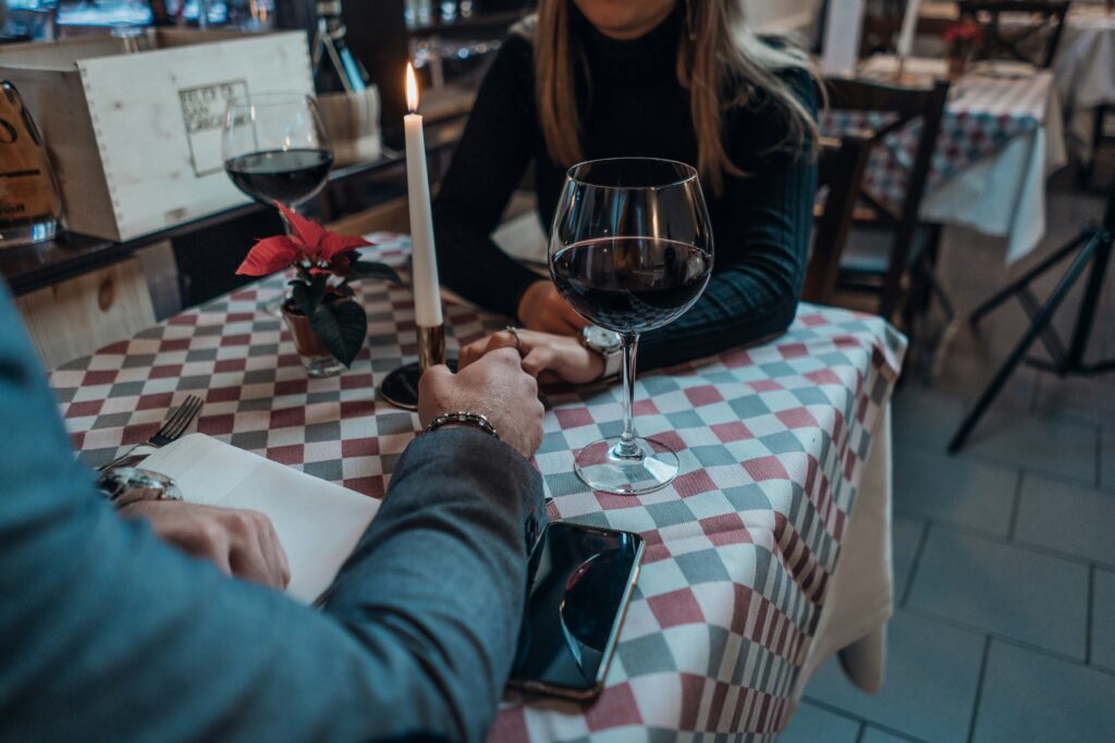 Couple holding hands at a table on a date.