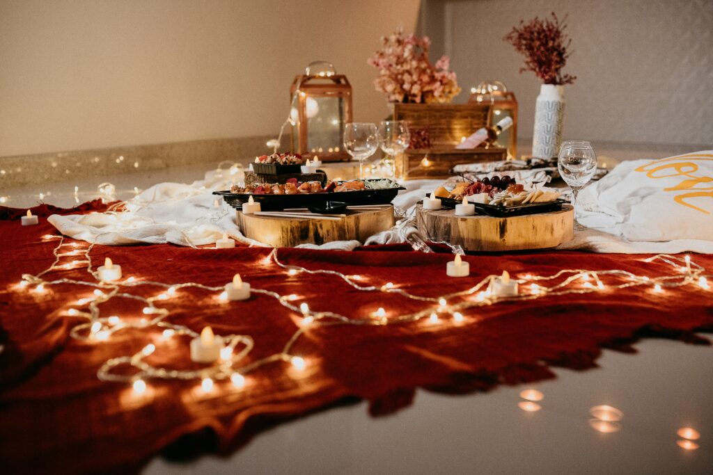 valentines spread of food on a red rug with fairy lights