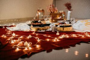 valentines spread of food on a red rug with fairy lights