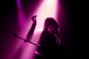 Lead singer of PVA performing onstage at Headrow House.